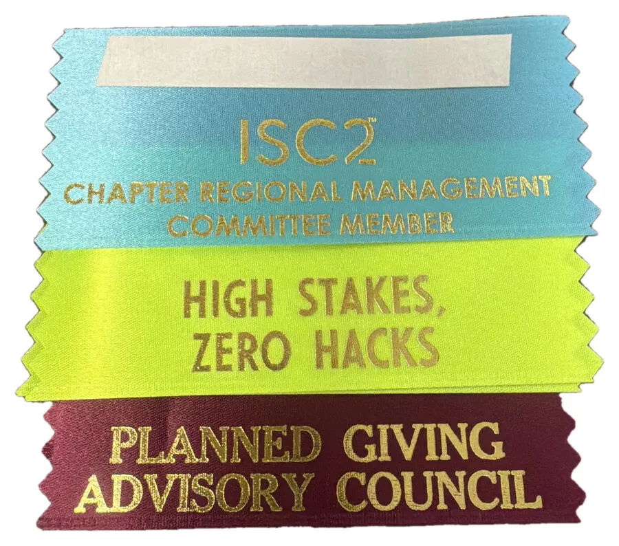 Three stacked badge ribbons in light blue, lime green and burgundy with gold printing